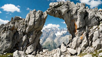 Rock Arch Framing Snowy Mountains