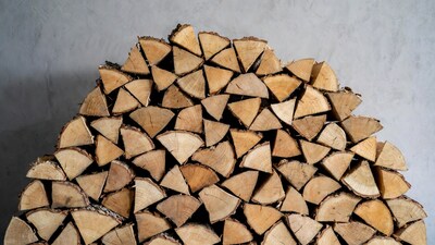 Stack of Firewood Against Gray Wall