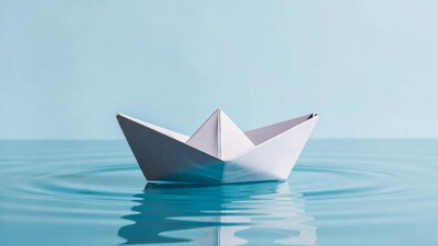 Paper boat floating on blue water