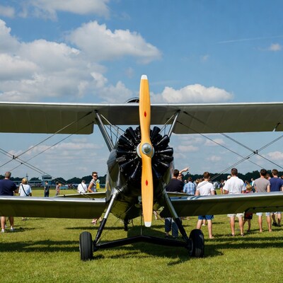 Biplane with crowd on grass airfield
