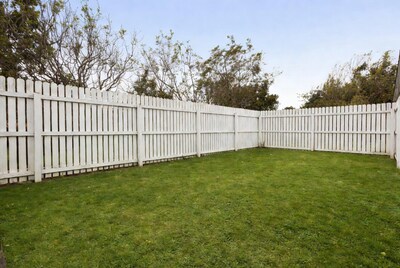 White picket fence enclosing grassy yard