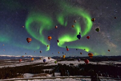 Hot air balloons under northern lights