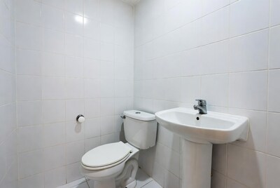 White tiled bathroom with toilet sink