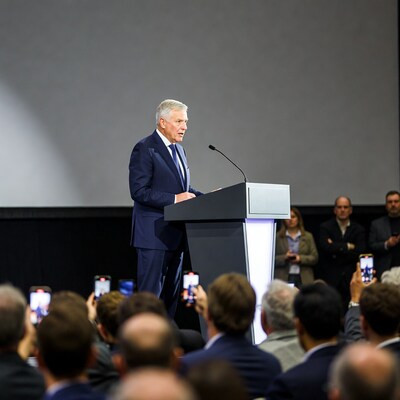 Man speaking at podium with audience
