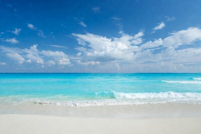 Turquoise ocean waves on white sand beach