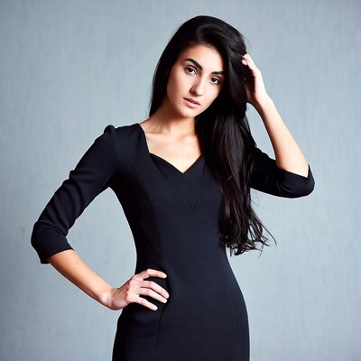 Woman in black dress hand on head