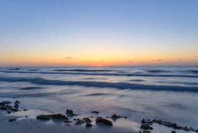Sunset over ocean waves and rocks