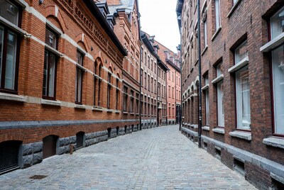 Narrow cobblestone alley between brick buildings