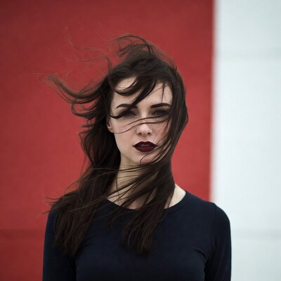 Woman with flowing hair against red wall