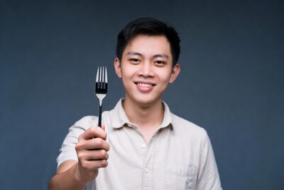 Asian man holding fork
