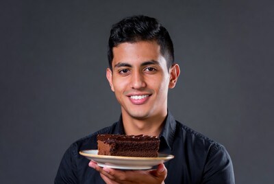 Young man holding chocolate cake