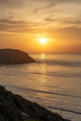 Sunset over ocean cliff