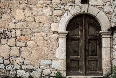 Stone wall with arched wooden door