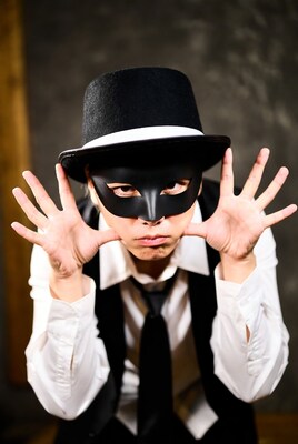 Man in black mask and top hat posing