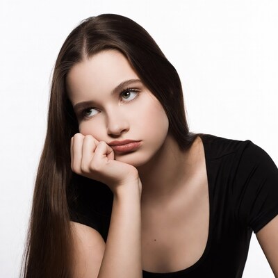 Teen girl resting chin on hand