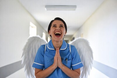 Nurse with angel wings laughing in hospital