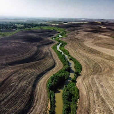 Aerial view of river through plowed fields