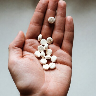 Man holding white pills in hand