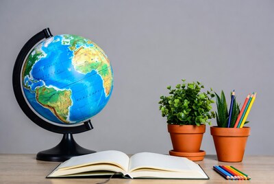 Globe with notebook and colored pencils