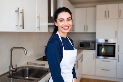 Smiling woman in apron in kitchen