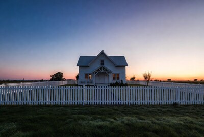 White house with picket fence at sunset