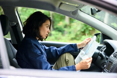 Asian woman reading map in car