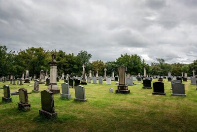 Graveyard with tombstones under cloudy sky