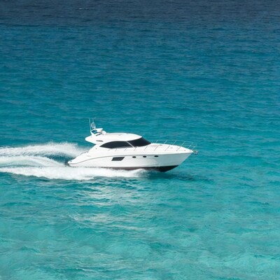 White yacht speeding on turquoise ocean