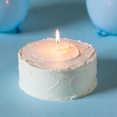 Birthday cake with candle and blue balloons