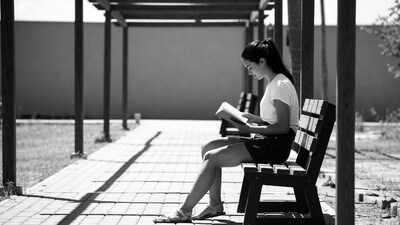 Woman reading book on bench