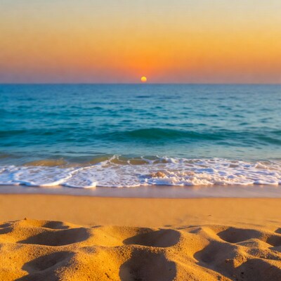 Sunset over beach with footprints