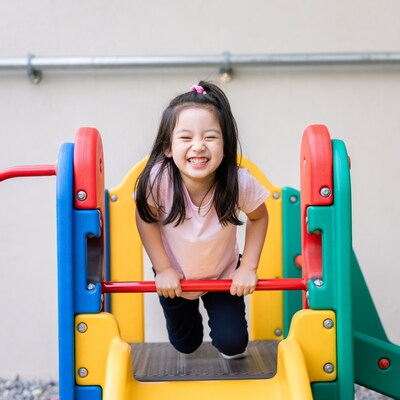 Asian girl smiling on playground slide