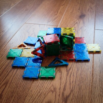 Colorful Magnatiles scattered on wooden floor