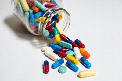 Colorful pills spilling from glass jar