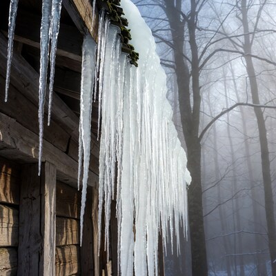 Icicles hanging from wooden cabin roof