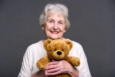 Elderly woman holding teddy bear
