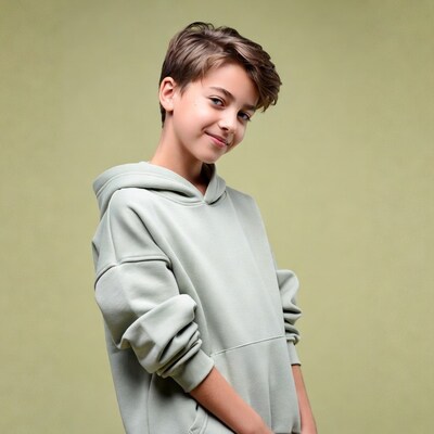 Boy smiling in hoodie on green background