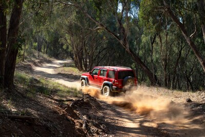 Red Jeep Wrangler off-roading forest trail