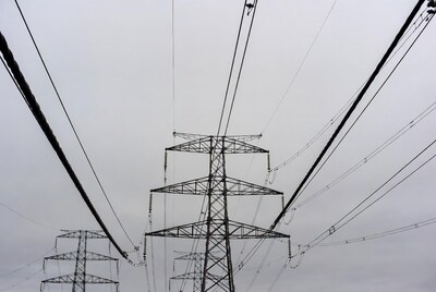 Electricity Pylons Against Cloudy Sky
