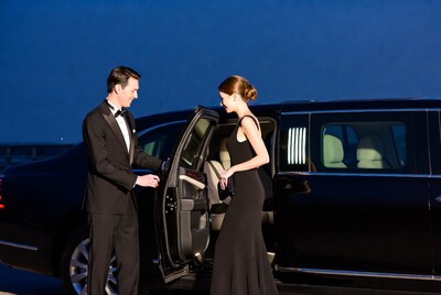 Man helping woman into limo