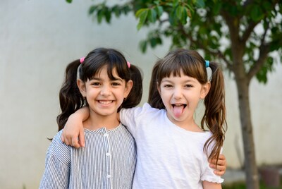 Two girls hugging with tongue out