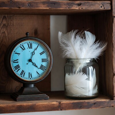 Blue Clock and White Feathers on Shelf