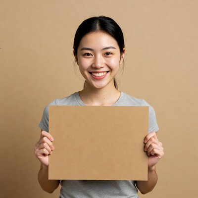 Asian woman holding blank cardboard sign
