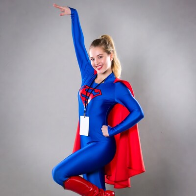 Blonde woman in Supergirl costume posing