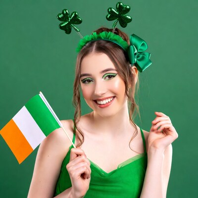 Woman in shamrock headband holding Irish flag