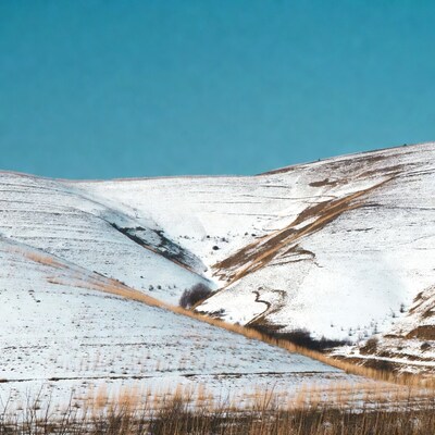 Snowy terraced hills under blue sky