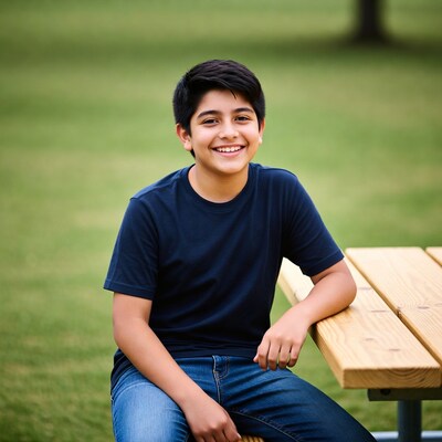 Smiling boy sitting on picnic table