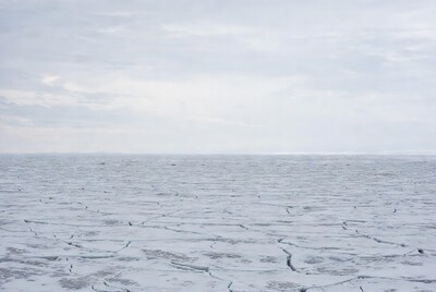 Cracked ice field under cloudy sky