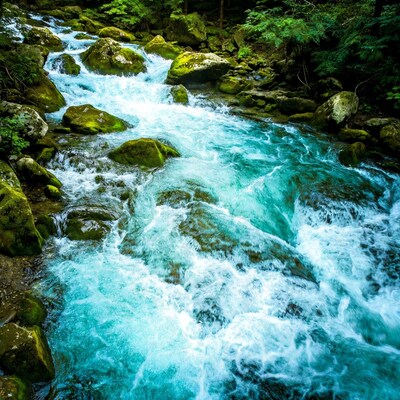 Turquoise river flowing over mossy rocks