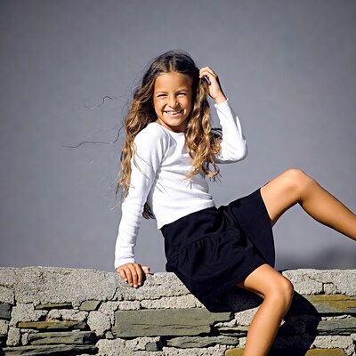 Smiling girl on stone wall